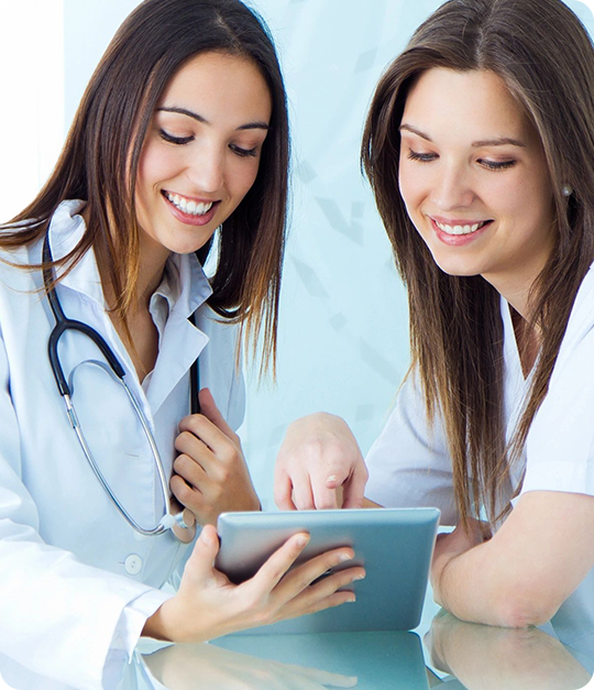 Two women are looking at a tablet.