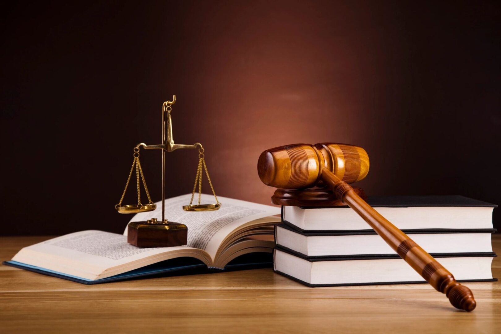 A judge 's gavel sitting on top of books next to a law book.