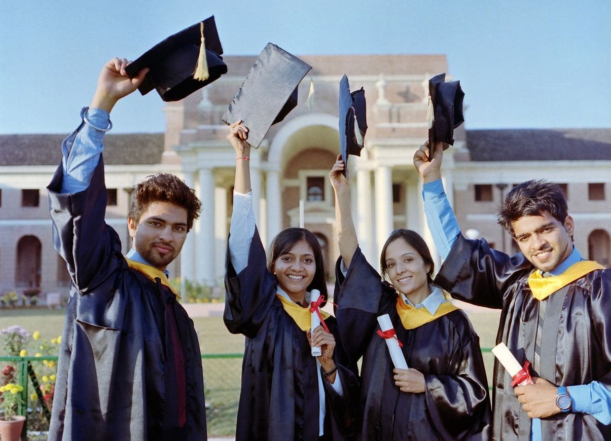 A group of people in graduation attire holding their caps.